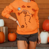 Orange Halloween crewneck sweatshirt with sequin skeleton and critter graphic front