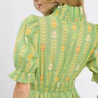 Sage green dress close-up of smocked yoke and embroidered ruffle cuffs