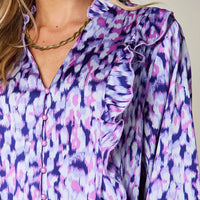 Purple printed shirt close-up with ruffled neckline and button front