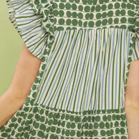 Green patchwork dress bodice close-up with dotted pattern and vertical striped panels.
