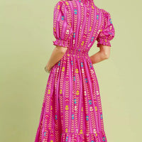Pink patterned midi dress with smocked bodice, ruffle collar, and puff sleeves (back view)