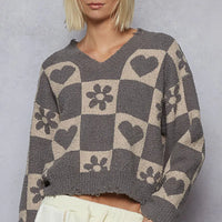 Womenโs V-neck heart checkered sweater in gray with beige heart and flower squares.