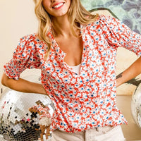 Floral V-neck top with smocked puff sleeves in orange with blue and white blossoms