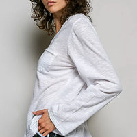 Off white long-sleeve knit V-neck top with contrast trim and chest pocket, side view.