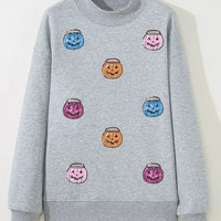 Gray sweatshirt on hanger with pumpkin-face graphic front and ribbed crew neck