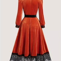 Orange-red velvet midi dress with black lace hem, long sleeves, fitted waist with tie belt