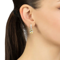 Silver oval drop earrings with yellow topaz, shown being worn on the ear