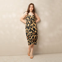 Woman wearing a cheetah print dress against a plain background