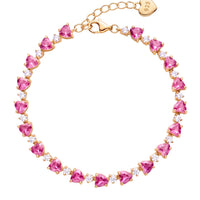 Gold-tone tennis bracelet with heart-shaped ruby-pink stones in a line