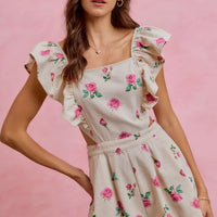Ivory floral romper with square neckline, ruffled cap sleeves and cinched cut-out waist