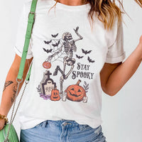 White Halloween graphic T-shirt with skeleton, pumpkins, bats, and 'STAY SPOOKY' print