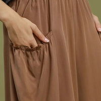 Brown pocket pants close-up, elastic waist and gathered details