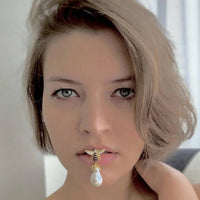 Bee-shaped pearl drop earrings in gold tone with crystal wings, worn