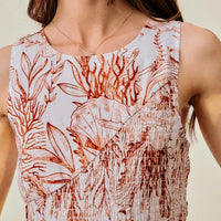 Close-up of coral and white shell-print sleeveless dress with smocked bodice detail