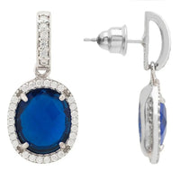 Silver drop earrings with blue oval gemstone and crystal halo, shown with back