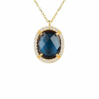 Gold oval gemstone pendant necklace with blue oval center and halo of clear stones
