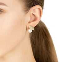 Gold-tone floral stud earrings with crystal details and a round pearl