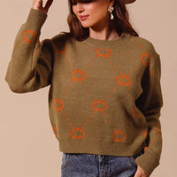 Olive crewneck sweater with orange pumpkin rhombus motif, ribbed cuffs