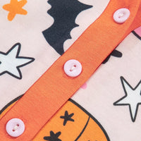 Close-up: orange button placket on dusty pink pumpkin-print long-sleeve pajama top
