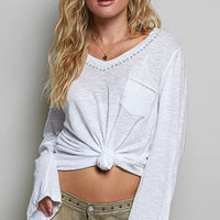 Off white V-neck long-sleeve knit top with chest pocket and contrast hand-stitched trim.