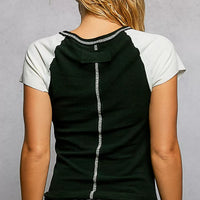 Black back of round-neck T-shirt with ivory contrast sleeves and outseam detail