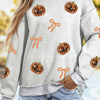 Light gray Halloween sweatshirt with orange sequin pumpkin faces and bow patterns