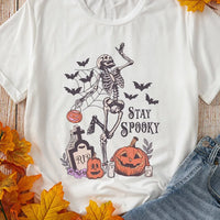 White Halloween graphic T-shirt with skeleton, jack-o'-lanterns, and 'STAY SPOOKY' text