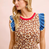 Leopard print knit top featuring blue ruffled cap sleeves and red neckline