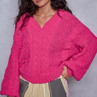 Fuchsia cable-knit cropped V-neck sweater with wide ribbed cuffs and textured knit detail