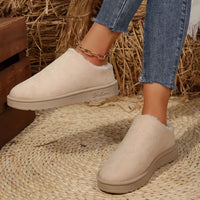 Off-white plush lined ankle boots with round toe, front view and low rubber outsole.