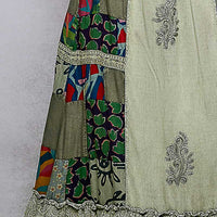 Close-up patchwork ruffled skirt panel with embroidered scrollwork and trims