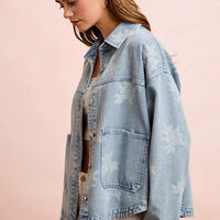 Light blue washed denim jacket with white floral print and chest pockets