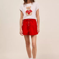 Red denim shorts with pintucked front, button closure, and elastic waistband.