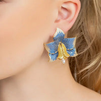 Blue crystal daffodil earrings with gold-tone charm and pearl drop, close-up