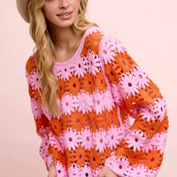 Orange and pink floral crochet top, long sleeves with openwork flower motifs.