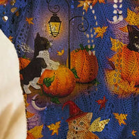 Plus size loose knit cover-up close-up with blue and purple fabric and orange pumpkin graphic.