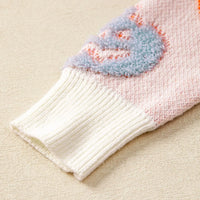 Dusty pink knit sweater cuff with ribbed white trim and blue ghost motif