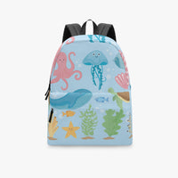 Kids canvas backpack front view with blue sea creatures design and black top loop.