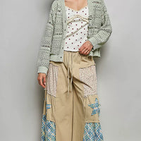 Light gray open-knit cardigan with button front and crochet rose appliques