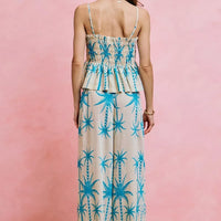 Back view of blue palm tree smocked bodice adjustable cami top with thin straps