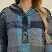 Plaid fleece hoodie close-up: hooded neckline with half-zip placket and textured pocket.
