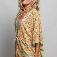 Floral print V-neck blouse with tie-front and relaxed quarter sleeves, green trim