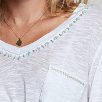 Off-white knit V-neck long-sleeve top with contrast-trim neckline and chest pocket