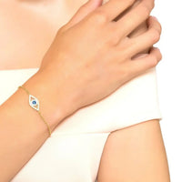 Gold-tone evil eye bracelet with blue center charm on wrist