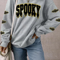 Gray pullover sweatshirt with sequin 'SPOOKY' front graphic and gold bat sleeve print