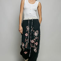 Off-white sleeveless ribbed tank top with round neck and button placket