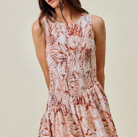 Lined sleeveless mini dress with smocked bodice and coral-brown shell print, tiered skirt