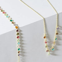 Gold multi-colored gemstone necklace angled view, round beads with colorful drops