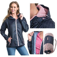 Women's navy polka dot rain jacket with pink trim, hood and packaway pouch