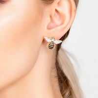 Rose-gold bee stud earrings on ear, crystal bee and wing details